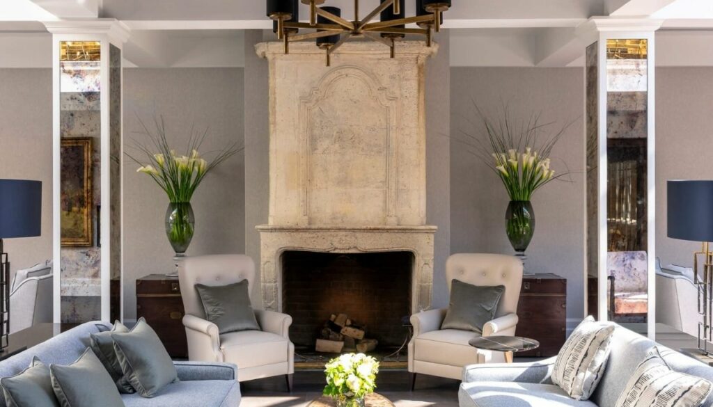 Bespoke sofas and upholstered armchairs arranged around a clubhouse fireplace