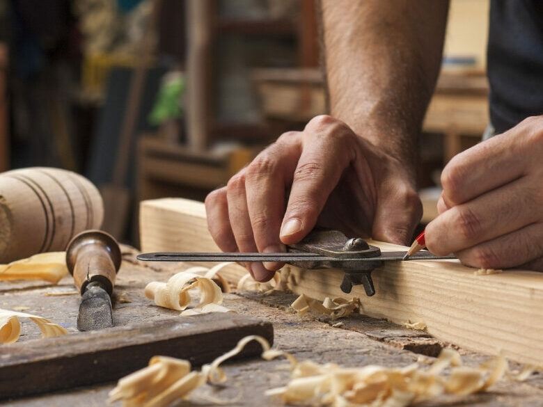 Furniture maker marking timber by hand during prototype development