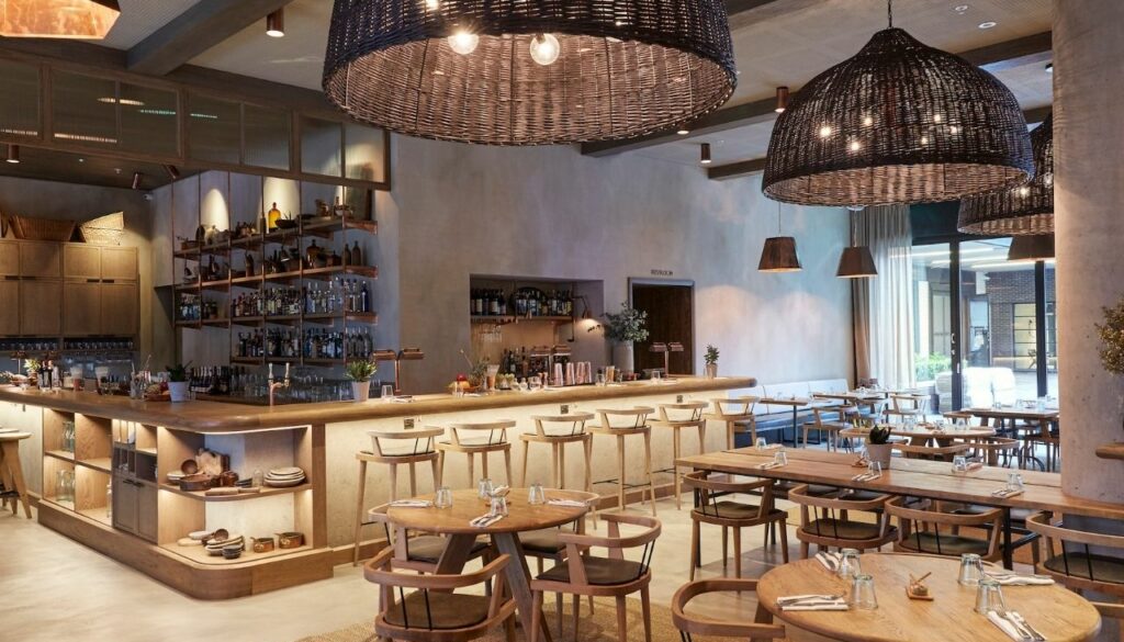 Bespoke wooden chairs and bar stools in the warm timber interior of Passo Restaurant, London