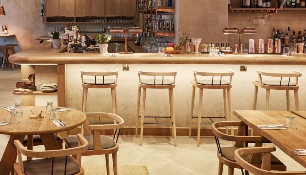Bespoke timber bar stools lined along the bar at Passo Restaurant, London